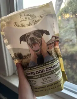 Katherine Heigl dog food: A bag of Badlands Ranch Superfood Complete Beef Formula dog food is held in front of a window.